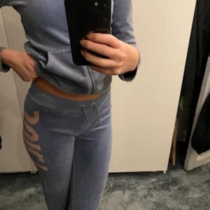 Juicy Couture - Säljer ett väldigt fint Juicy Coutore set i en superfin blå färg med ich rosa/peach bokstäver på ryggen av tröjan, och sidan av byxan! Just den här designen tillverkas inte längre! Byxorna är något korta, men passar nog någon som är lite kortare! Skulle säga att sättet passar xxs/xs! Startar budet på 750kr!