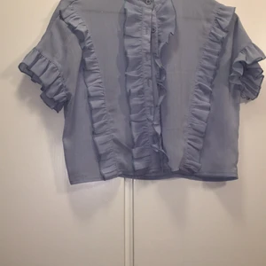 Ljusblå kortärmad blus  - Volang