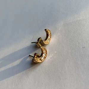 Måne formade örhängen - Guldiga måne formade örhängen med fake-diamanter. Ej använda. En liten sten saknas. (Kommer helt nytvättade) betalning sker över swish (köpare står för frakt)