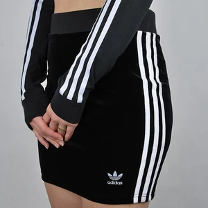 Adidas sammet kjol - Fin svart adidas kjol i sammet med tre vita stripes på båda sidorna(första bilden lånad), och suuper skön! Den är i storlek 36 men passar mig som har 38 eftersom den är väldigt stretchig. Sparsamt använd😁 köparen står för frakten!!