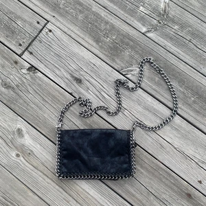 Svart väska - En svart väska i skimrigt tyg. Den är mjuk och liknar en Stella McCartney. Nästan helt oanvänd, så i väldigt bra skick! 