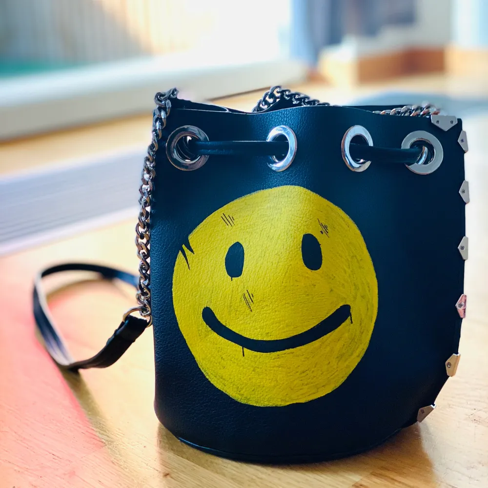 En pouch väska med en smiley. . Väskor.