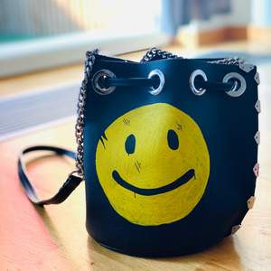 En pouch väska med en smiley. 