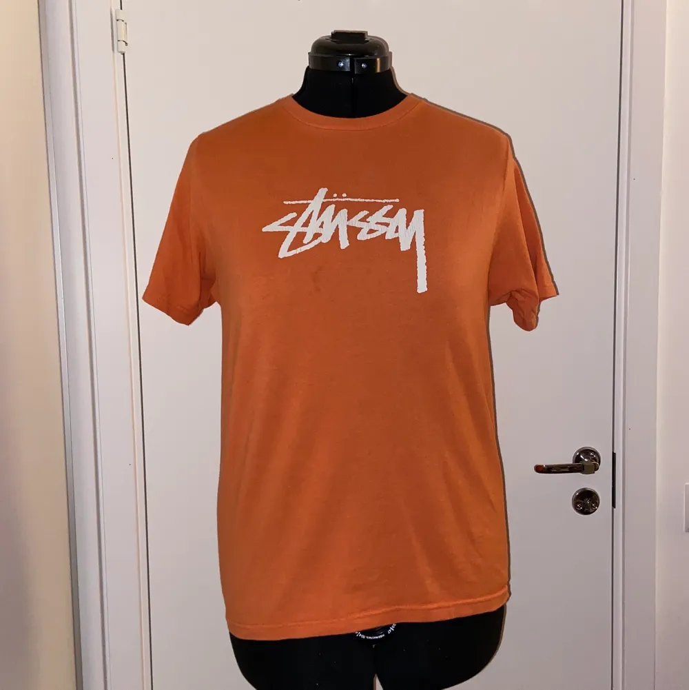 Stüssy graphic tee orange, använd ett fåtal gånger, så gott som ny. T-shirts.