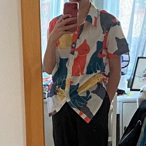 kortärmad kattskjorta från SHEIN - färgglad kattskjorta från shein! sitter oversized! supersöt! frakt tillkommer! skickar med extras (t.e.x godis och/eller skönhetstesters) i varje paket så kolla in mina andra varor vetja! ha en bra dag! <3