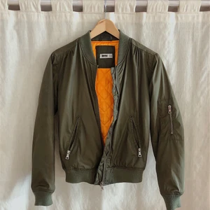 JACKA - Sjukt cool militärgrön jacka från DMretro, knall orange insida med fickor! 
