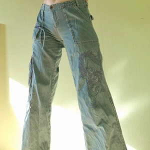 Funky pants w dragon embroidery  - Ljust blågröna byxor i tyg🐉broderad drake på ena byxbenet, dragkedjor på sidan av benen så man kan ha "slits" till strax under knät. köpa i Tel Aviv! Lågmidjade o utsvängda längst ner, snygg passform 💥  köparen står för frakten! möts annars gärna upp i Göteborg :) buda i kommentarerna❣🐙 (inga oseriösa bud!!) 