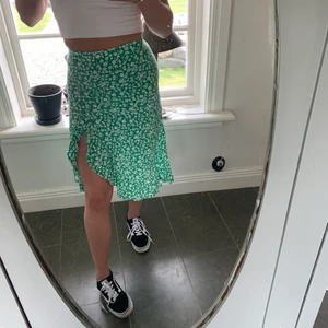 Sommarkjol  - Grön, blommig kjol med slits! Köpt på bershka och i bra skick, säljer då den är för liten! Köparen står för frakten💗