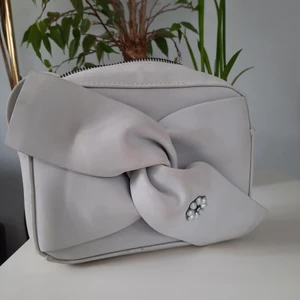 Axelbandsväska - Axelbandsväska med blomma på. Grå men använd så har lite fläckar därav priset