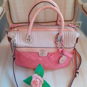 Guess väska  - Säljer en fin Guess väska, den är som ny helt oanvänd! Höjd 23cm längd 40cm bred 15cm. Skriv snabbt om intresserad!💗