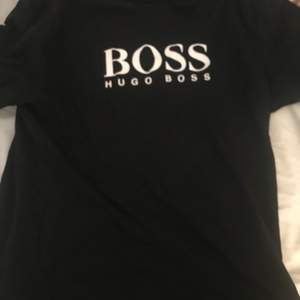 Hugo boss tröjan är svart och det står med vitt Hugo boss
