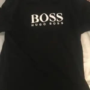 Hugo boss tröjan är svart och det står med vitt Hugo boss