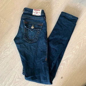 True Religion Jeans  - Säljer dessa snygga straight true religion jeans då jag redan har likadana. De är i  w24 men passar mig som vanligtvis har w26. Jag har dragit isär dragkedjan som syns på bild nr 3 så att det ska vara enklare att få på sig dem. Detta går dock enkelt att sätta tillbaka med en tång. De är helt i nyskick och passar perfekt i längden på mig som är 166cm lång. Kom privat för bilder med dem på! ❤️ 