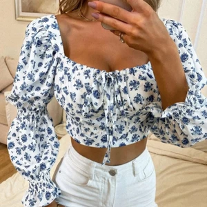 Vit topp - Vit topp med blåa blommor, storlek M men passar S och M, aldrig använd 