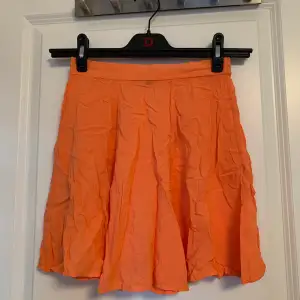 Orange/pärsika-färgad kjol från BikBok i storlek XS. Det är resår i bak så den är stretchig. 