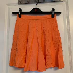 Orange/pärsika-färgad kjol från BikBok i storlek XS. Det är resår i bak så den är stretchig. 