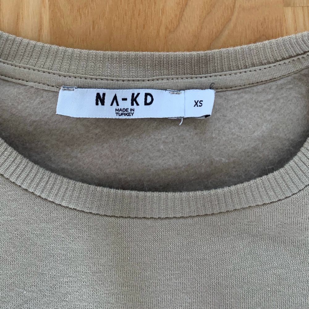 Sweatshirt från NA-KD, beige med lite ballongärm, rå kant nertill och vid i modellen, supersnygg! Knappt använd. Strl xs. . Tröjor & Koftor.