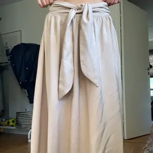 Beige kjol från hm köpt för två år sen, endast använd några få gånger. Perfekt för sommaren med knyte i midjan, storlek 38💕  Frakt tillkommer (varierar på hur mycket paketet väger) men kan mötas upp i Göteborg. 