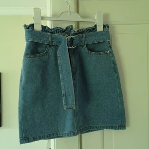 Jeanskjol  - Ljusblå jeanskjol med midjeskärp. 