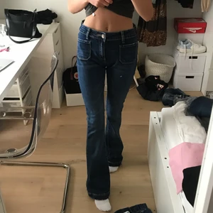 Mörkblå lågmidjade bootcut jeans - Mörkblå lågmidjade bootcut jeans med coola fickor från Black Lexxury, modellen flare! Insydda i midjan för att passa mig som har 24-25 men går att sprätta🥰 står ingen storlek men passar som en xs-s! Kan hämtas i slussen eller postas😊
