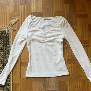 Vit topp - Vit topp med detaljer fram. Helt ny. Frakt blir billigare vid köp av flera plagg