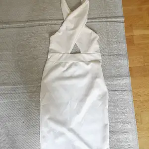 Materialet är bomull och polyester. Halterneck. Dubbelt tyg i bröstdelen så den täcker bra. Liten slits längst ner bak på kjolen. Elegant och snygg! Aldrig använd för har bara aldrig blivit tillfälle och nu har jag vuxit ut den. 