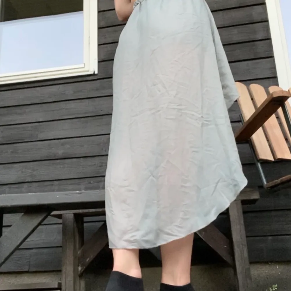 Finfin grå kjol i tunnt tyg. Säljer för att den aldrig kommer till användning, resor i midjan och tyget rör sig jättefint :). Kjolar.