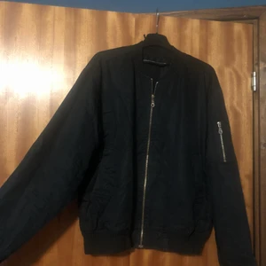 bomberjacka i storlek M - En svart bomberjacka som är Använd 1 höst, bra skick, silvrig dragkedja, en liten ficka med dragkedja på vänstra armen och 1 vanlig ficka på varje sida av jackan