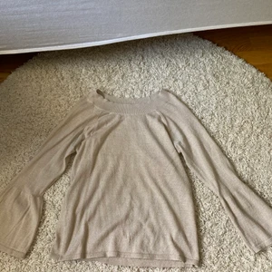 Kappahl stickad blus - Beige tröja/blus med lite guldglitter. Utsvängda ärmar och passar perfekt både till vardag och finare middag. Stl L men passar även M. Sparsamt använd