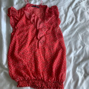 Tunn röd tröja, str 36 - Denna fina blommiga blus är lite genomskinligt men passar utmärkt med ett linne under! 
