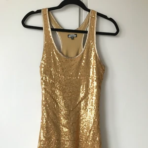 Bikbok guldig paljettklänning  - En superfin paljettklänning i guld från Bikbok, size XS, använd väldigt sparsamt och nu har jag växt ur den 🦋 har superfin brottarrygg och är mini-längd 🌞