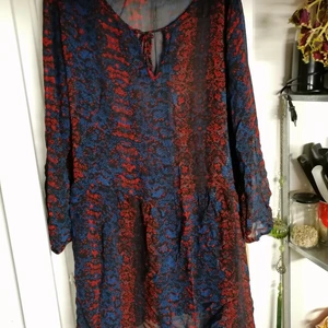 Rymlig tunika från Indiska - En rymlig tunika från Indiska, storlek XL, tunn tyg, bra skick. Färg: svart-röd-blå. 