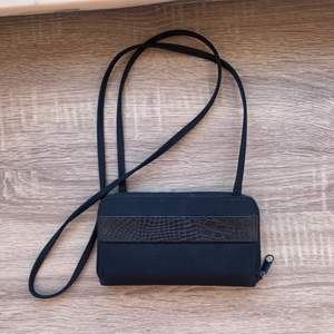 Liten svart plånboksväska med en fakeskinn detalj. Vet inte vart den kommer ifrån då den e gammal💗🌸