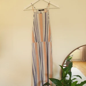 Randig långklänning stl M - Randig långklänning med slitsar på båda sidorna. Från BikBok stl M. Mjukt t-shirt material. Knappt använd men har några år på nacken. Frakt tillkommer.