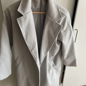 Kappa  - Säljer min gråa kappa. Den har spräckts lite i sömmen (se 2 bild). Har inte försökt laga detta då det inte syns eller stört mig när jag använt den. Använt den fåtal gånger! 