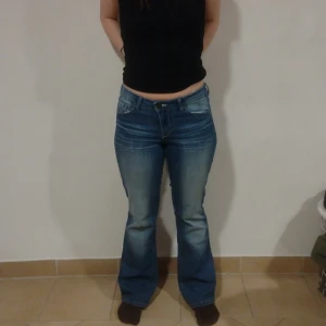 Low rise blue jeans - Säljer dessa sjukt snygga blå bootcut jeans då de inte används längre. de är i nyskick och har en snygg detalj på bakfickan.