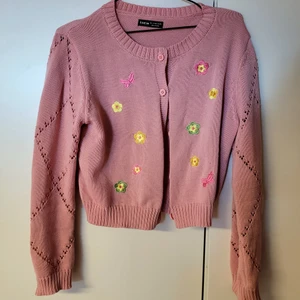 Blommig kofta - Rosa stickad kofta med broderade blommor! Verkligen jättesöt men kommer inte till användning för mig. Färgerna är ganska starka, jag har försökt representera dem så väl som möjligt på bilderna. Nyskick 💖