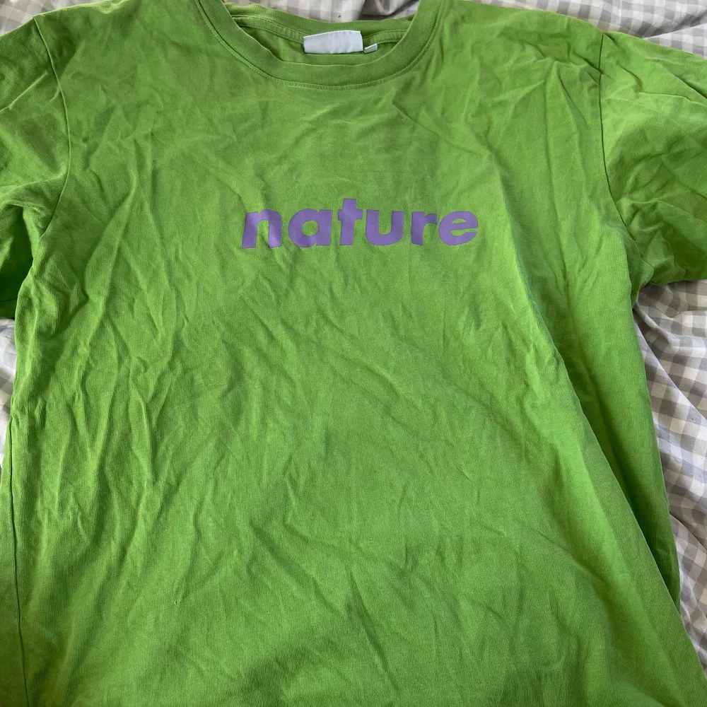 Grön boxig T-shirt med lila tryck på, sitter coolt men har inte riktigt fått användning för den, köpt på plick för ett år sedan, strlk s men mer som en M. 20kr+frakt. T-shirts.