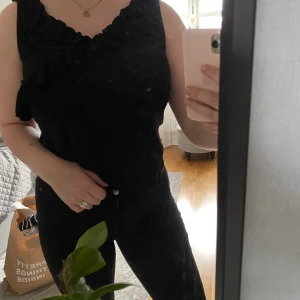 Gulligt svart linne med volang - Jag säljer detta supergulliga linne, jag har använt den Max 5 gånger för att jag själv inte tycker jag passar i den men de är inget fel med den. Den kommer från ett rökfritt hem och tvättas alltid innan den skickas och har du fler frågor är de bara att höra av dig.