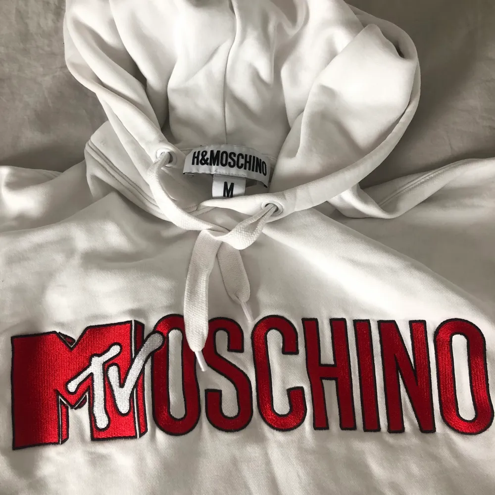Vit hoodie med rätt broderat tryck från H&M x Mochino kollektionen. Väldigt sparsamt använd, inga skavanker eller noppor! Är lite ”oversize” i modellen, alltså inte tight. Tröjor & Koftor.