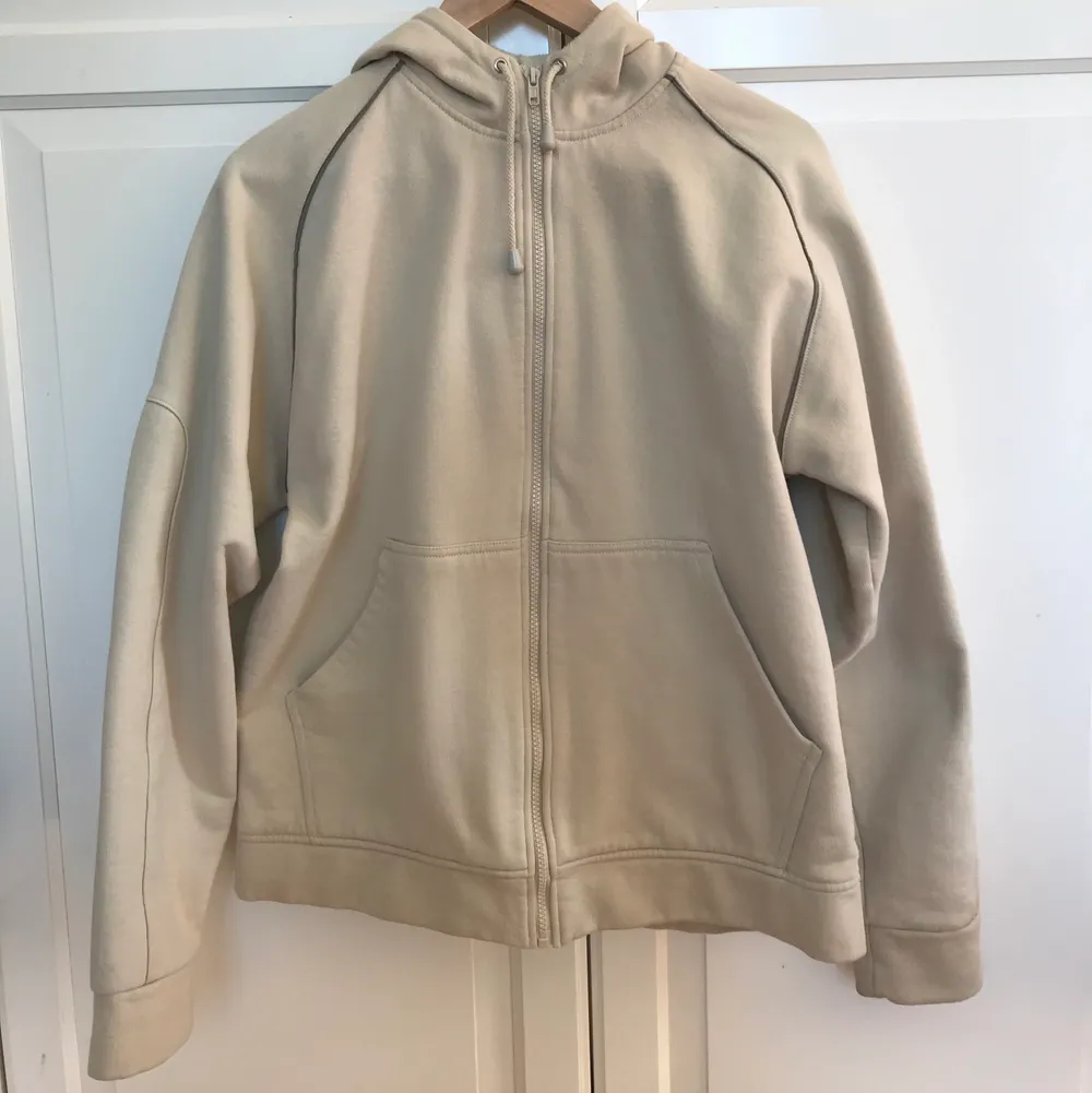 En beige hoodie som är lite oversized med fina detaljer på ärmarna. Det står storlek L men passar mer som en stor M.. Tröjor & Koftor.