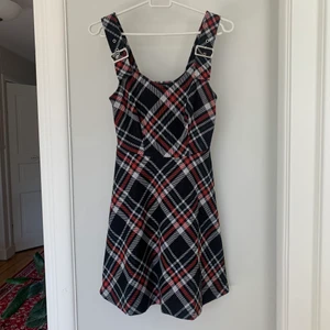 Rutig klänning med spännen  - Fin, rutig klänning i a-line-modell med metallspännen på axelbanden