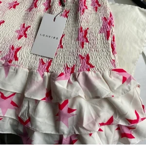 Kjol med stjärnor  - Lägger ut igen pga oseriösa köpare ❌Vit volang kjol med stjärnor på från Loavies. Prislappar kvar. Storlek S men har resår och passar därför Xs-M. Köp direkt för 400 🚨Bud:290kr 🚨 BUDA ENDAST VID INTRESSE, oseriösa blockas!