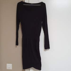 Enkel svart klänning med slits på vänstra sidan.