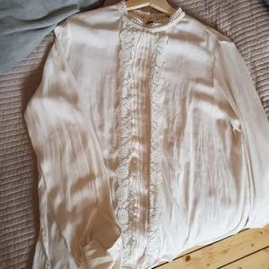 Söt vit sommarblus  - Blusen är gräddvit med spetsdetaljer och små volanger vid händerna. I storlek 40 men passar 36-40.  Köparen står för frakt. Skicka meddelanden för fler bilder/info! 💕