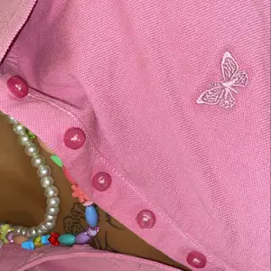 Pikétröja i fin rosa färg från M.X.O med en fjäril på vänster sida. 