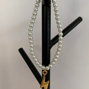 Vitt pärlarmband med guldig blixtberlock - Vitt pärlarmband med guldig blixtberlock⚡️ Pris:39kr/st. Fraktkostnad på 12kr tillkommer.