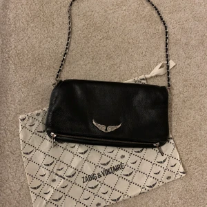 Zadig & Voltaire ROCK handväska - Säljer min sparsamt använda Zadig väska som är nyinköpt för ca 2 år sen, använd Max 7gg men har tyvärr tappat bort det långa bandet men det korta finns och dustbagen medföljer. Nypris 3 265kr. 