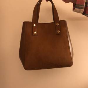 Väskan är aldrig använd och i toppskick! Brunt fint läder och ett längre snöre!💕 Guld knappar som detaljer