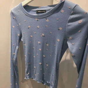 Blommig tröja - Ribbad blå tröja med söta blommor på🌸, storleken är XXS men passar iaf upp till vanlig S då den är rätt så stretchig!